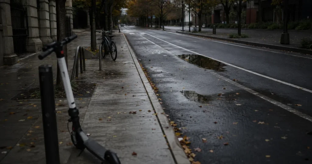 Tom cykelväg i stad med en elsparkcykel parkerad vid trottoarkanten