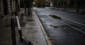 Tom cykelväg i stad med en elsparkcykel parkerad vid trottoarkanten